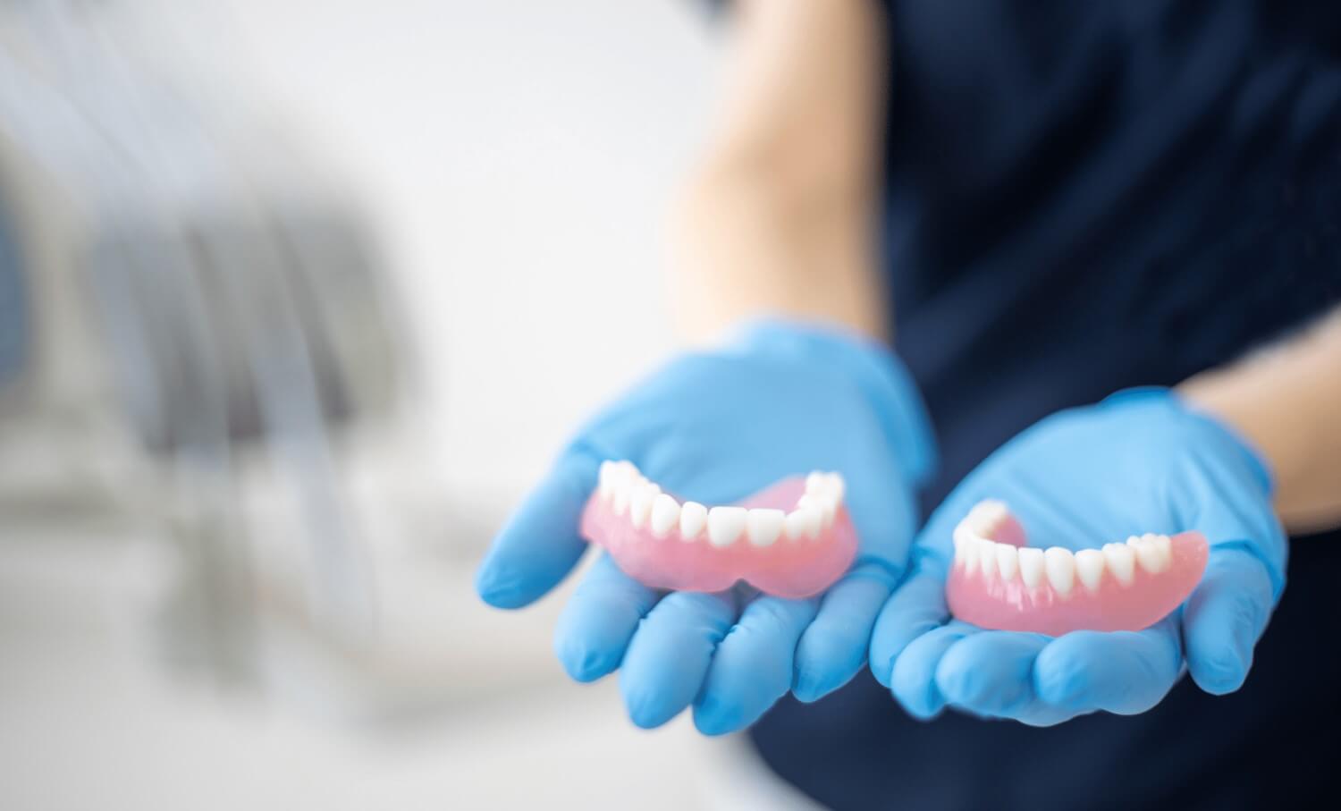 Dental professional holding dentures